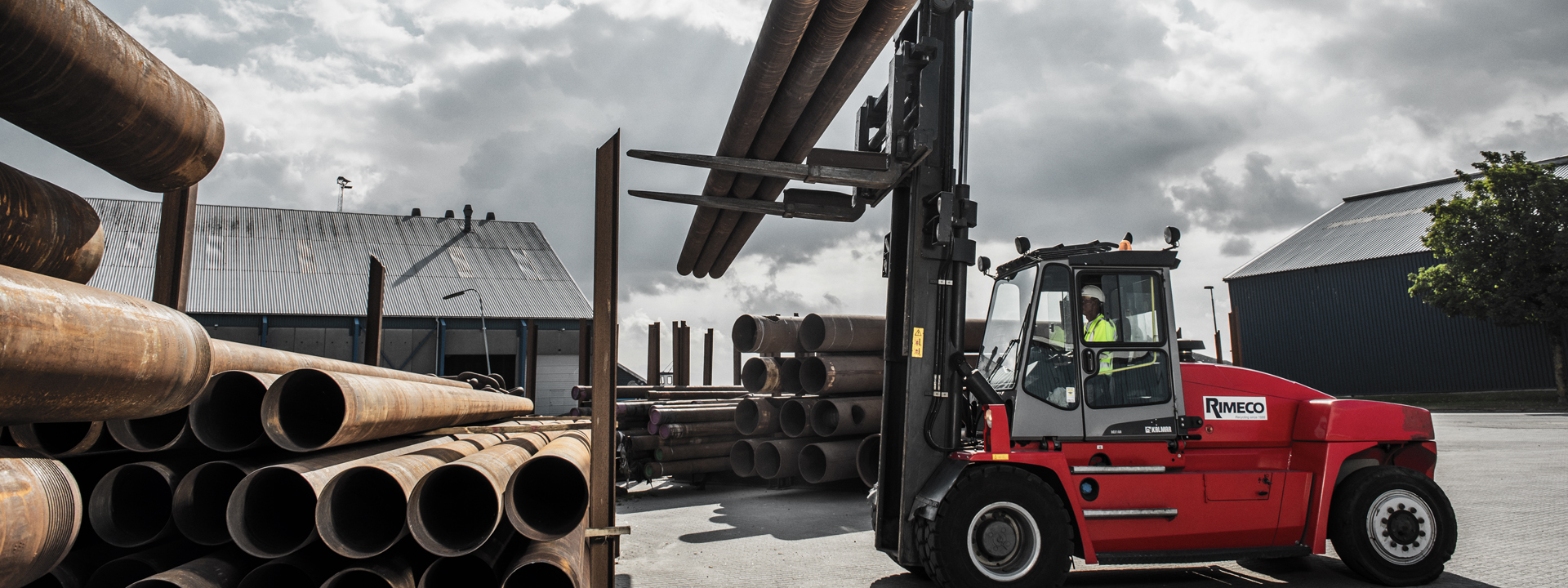 forklift lifting three metalrods